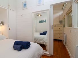 A bedroom with a bed and dresser at 2 Brook Cottages in Hope Cove