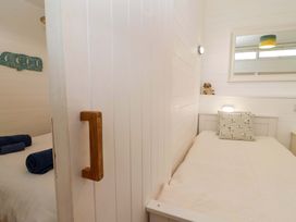 A twin bedroom with beds and a mirror at 2 Brook Cottages Hope Cove