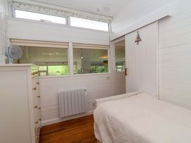 A bedroom with a bed and window at 2 Brook Cottages in Hope Cove