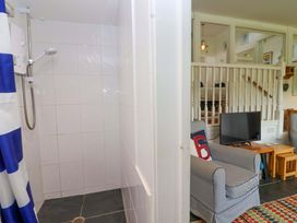 A bathroom with a shower and a seating area at 2 Brook Cottages, Hope Cove