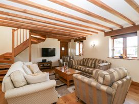 A living room with a sofa and television at Penrhiwarwydd Barn in Pontywaun