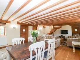 A living room with a dining area and staircase at Penrhiwarwydd Barn, Pontywaun
