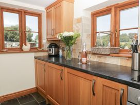 A kitchen with cabinets and countertop at Penrhiwarwydd Barn in Pontywaun