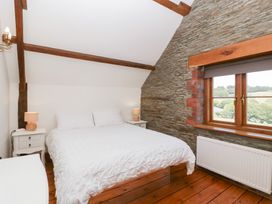 A bedroom with a bed and nightstand at Penrhiwarwydd Barn in Pontywaun