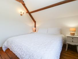 A bedroom with a bed and nightstands at Penrhiwarwydd Barn in Pontywaun