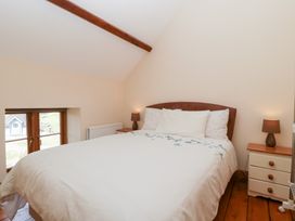 A bedroom with a bed and lamps at Penrhiwarwydd Barn in Pontywaun