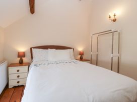 A bedroom with a bed and nightstand at Penrhiwarwydd Barn Pontywaun