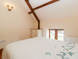 A bedroom with a bed and a window at Penrhiwarwydd Barn Pontywaun