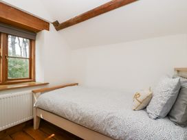A bedroom with a bed and window at Penrhiwarwydd Barn in Pontywaun