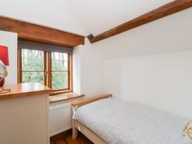 A bedroom with a bed and window at Penrhiwarwydd Barn Pontywaun