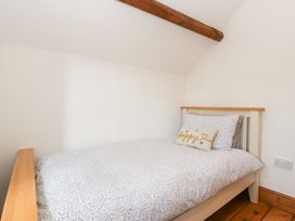 A bedroom with a single bed and pillow at Penrhiwarwydd Barn in Pontywaun