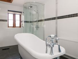 A bathroom with a bathtub and shower at Penrhiwarwydd Barn in Pontywaun