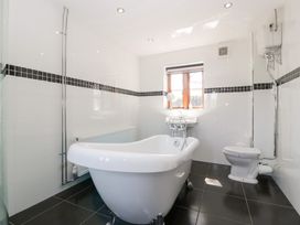 A bathroom with a bathtub, sink and toilet at Penrhiwarwydd Barn Pontywaun