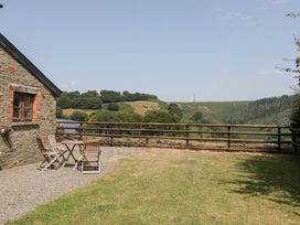 An outdoor seating area with a table and chairs at Penrhiwarwydd Barn, Pontywaun