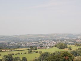A view of fields and hills with a distant town at Penrhiwarwydd Barn Pontywaun