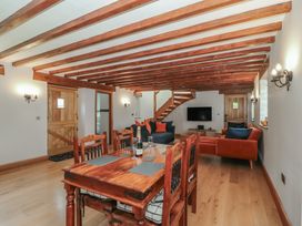 A living room with a dining table and sofa at Penrhiwarwydd Barn in Pontywaun