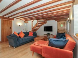 A living room with a sofa and a television at Penrhiwarwydd Barn in Pontywaun