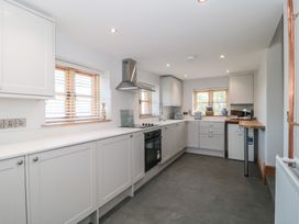 A kitchen with cabinets, countertop, and appliances at Penrhiwarwydd Barn in Pontywaun