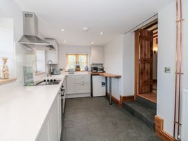 A kitchen with a stove, microwave, and refrigerator at Penrhiwarwydd Barn in Pontywaun