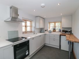 A kitchen with cabinets and appliances at Penrhiwarwydd Barn in Pontywaun