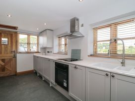 A kitchen with cabinets and appliances at Penrhiwarwydd Barn in Pontywaun