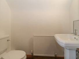 A bathroom featuring a toilet, sink, and radiator at Penrhiwarwydd Barn, Pontywaun