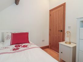 A bedroom with a bed and a door at Penrhiwarwydd Barn in Pontywaun