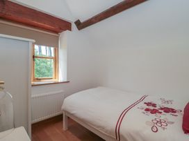 A bedroom with a bed and a window at Penrhiwarwydd Barn Pontywaun
