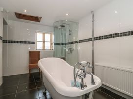 A bathroom with a bath tub and shower at Penrhiwarwydd Barn in Pontywaun