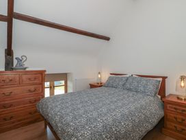A bedroom with a bed and furniture at Penrhiwarwydd Barn in Pontywaun