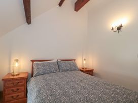 A bedroom with a bed and bedside tables at Penrhiwarwydd Barn in Pontywaun