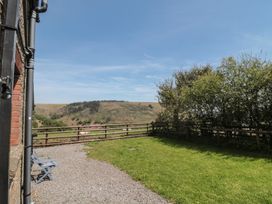 A garden with a fence and hill view at Penrhiwarwydd Barn Pontywaun