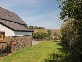 An exterior view of a property with grass and trees at Penrhiwarwydd Barn in Pontywaun