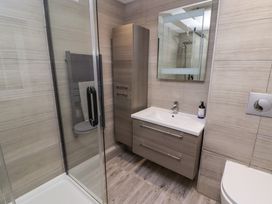 A bathroom with a glass shower enclosure sink with cabinet mirror and toilet at Hiraeth in Cwmtaf near Cefn-Coed-Y-Cymmer