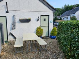 An outdoor area with a table and benches at Dove Cottage in Llanfair Talhaiarn