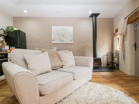 A living room with a sofa and stove at Caner Bach Lodge in Blackmill
