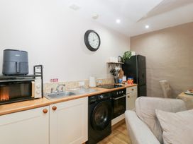 A kitchen with appliances and a table at Caner Bach Lodge in Blackmill