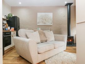 A living room with a sofa and wood stove at Caner Bach Lodge in Blackmill