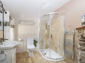 A bathroom with shower and sink at Caner Bach Lodge Blackmill