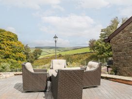 An outdoor seating area with a table and chairs at Caner Bach Lodge in Blackmill