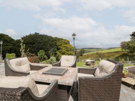 An outdoor seating arrangement with a table and a garden lamp at Caner Bach Lodge in Blackmill