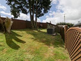 A garden area with grass and trees at Caner Bach Lodge Blackmill