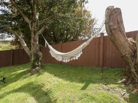 A garden with a hammock hanging between trees at Caner Bach Lodge Blackmill