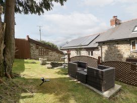 A garden with seating area and stone features at Caner Bach Lodge in Blackmill