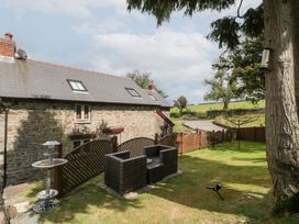 A garden with a house and seating area at Caner Bach Lodge in Blackmill
