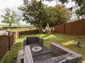 A garden with outdoor seating and a hammock at Caner Bach Lodge in Blackmill