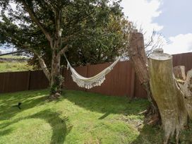 A garden with a hammock between trees at Caner Bach Lodge, Blackmill