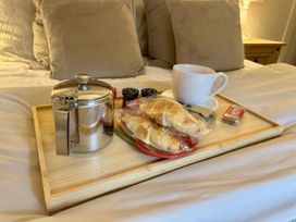 A tray with tea pot croissants and a cup at Caner Bach Lodge in Blackmill