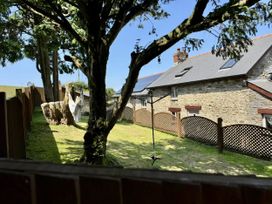 A garden with a tree and a fence at Caner Bach Lodge in Blackmill