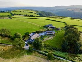 An aerial view of a farmhouse and fields at Caner Bach Lodge in Blackmill